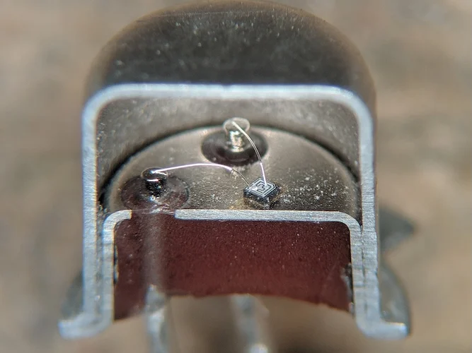 A cross-section of a 2N2222 in metal TO-18 package, showing connection wires between external pins and the die. 